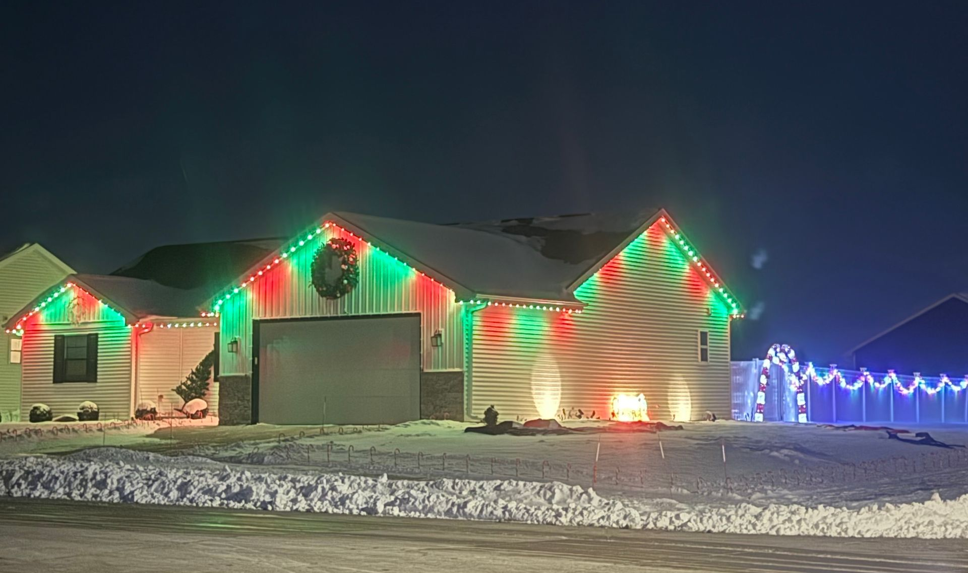 House decorated with white Christmas lights at night.
