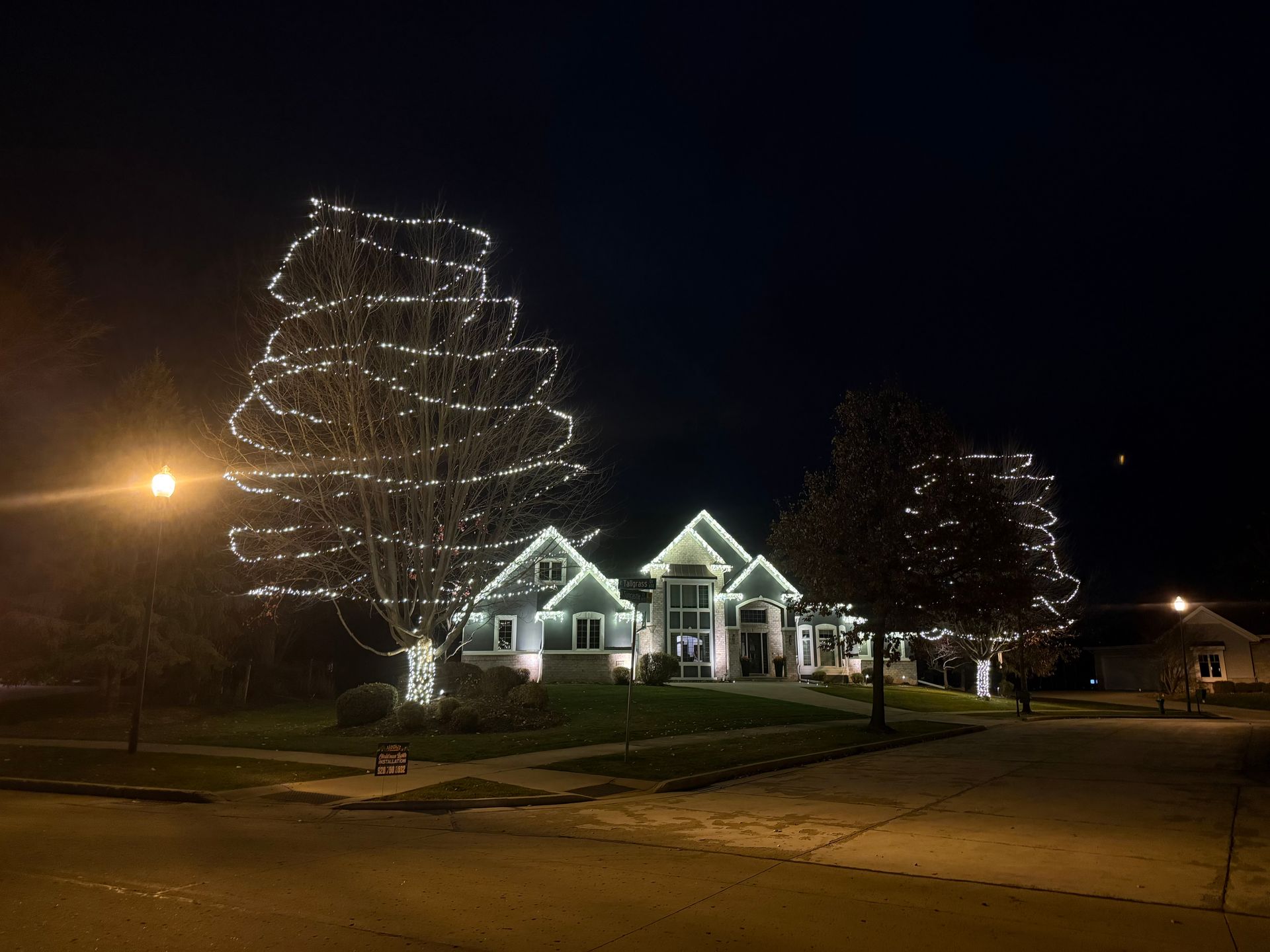 A house is decorated with christmas lights at night.
