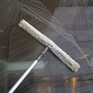 Window being cleaned with a long-handled applicator