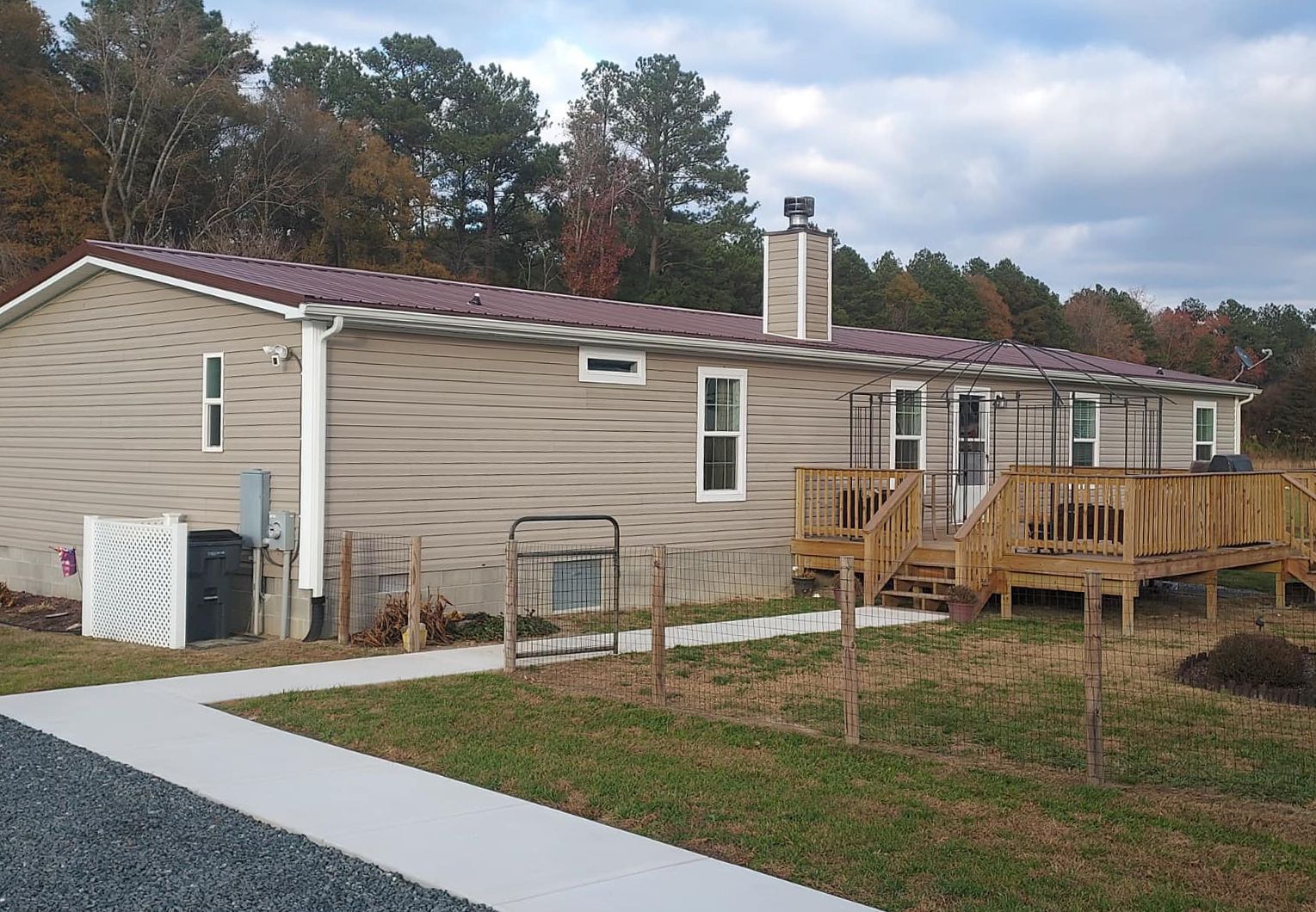 A mobile home with a concrete walkway leading to it.