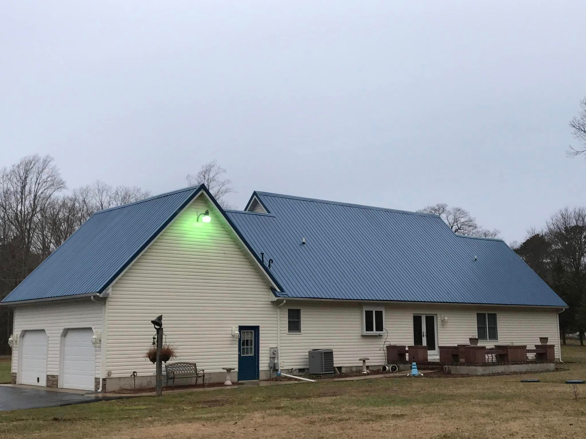 A white house with a blue roof and a garage