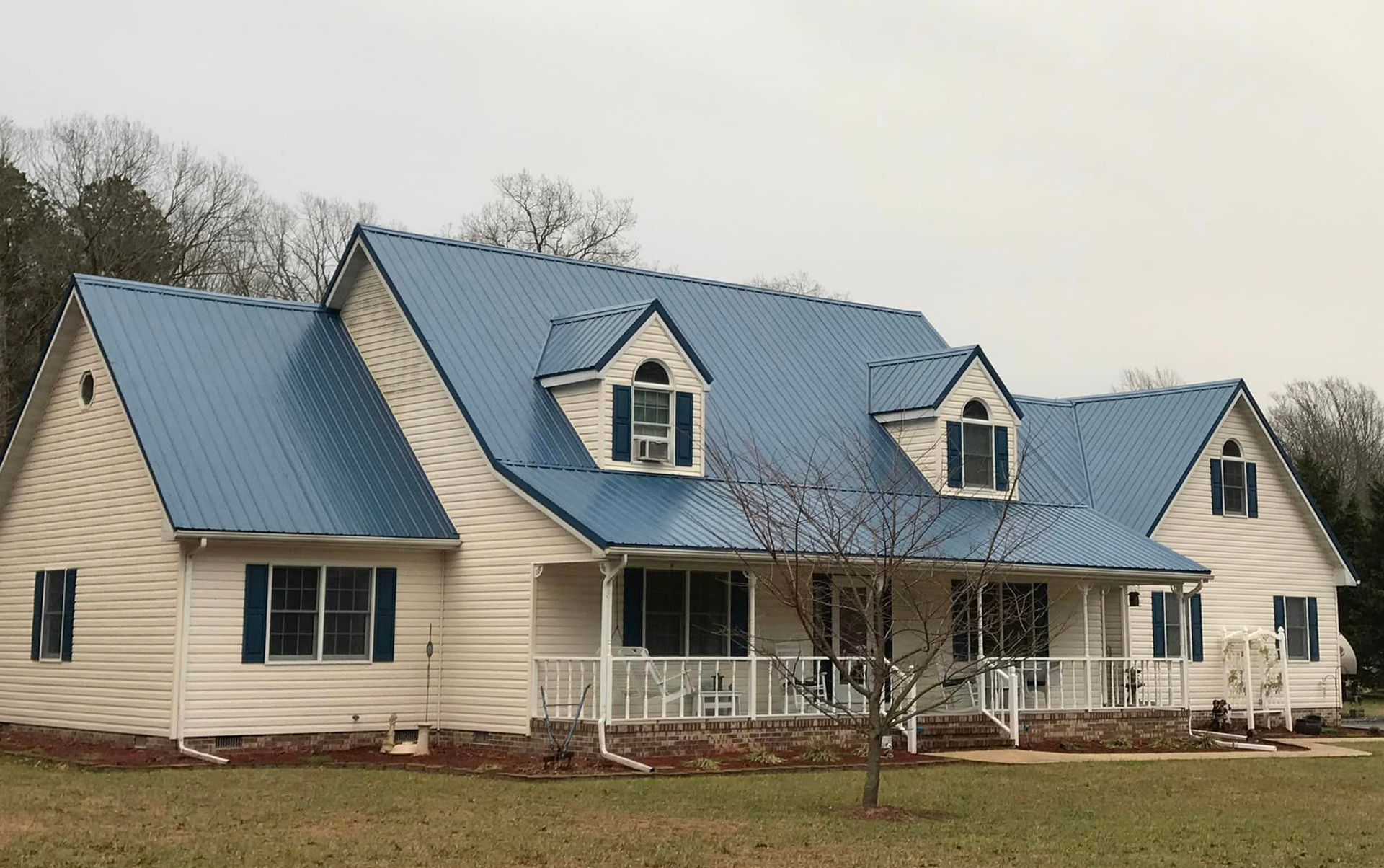 A white house with a blue roof and blue shutters