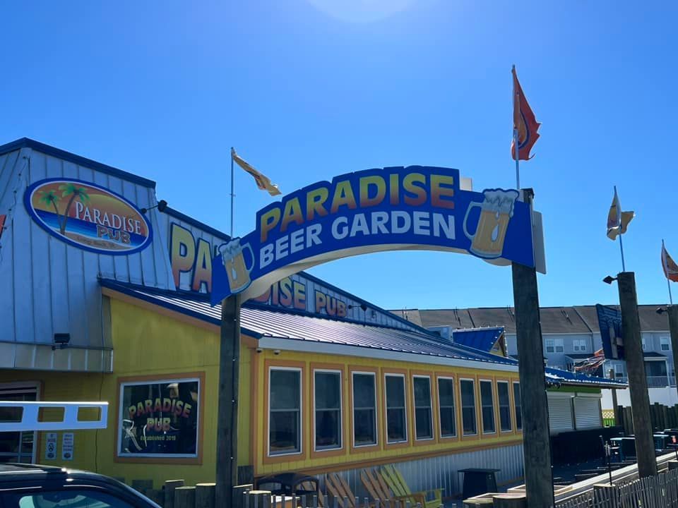 A yellow building with a sign that says paradise beer garden