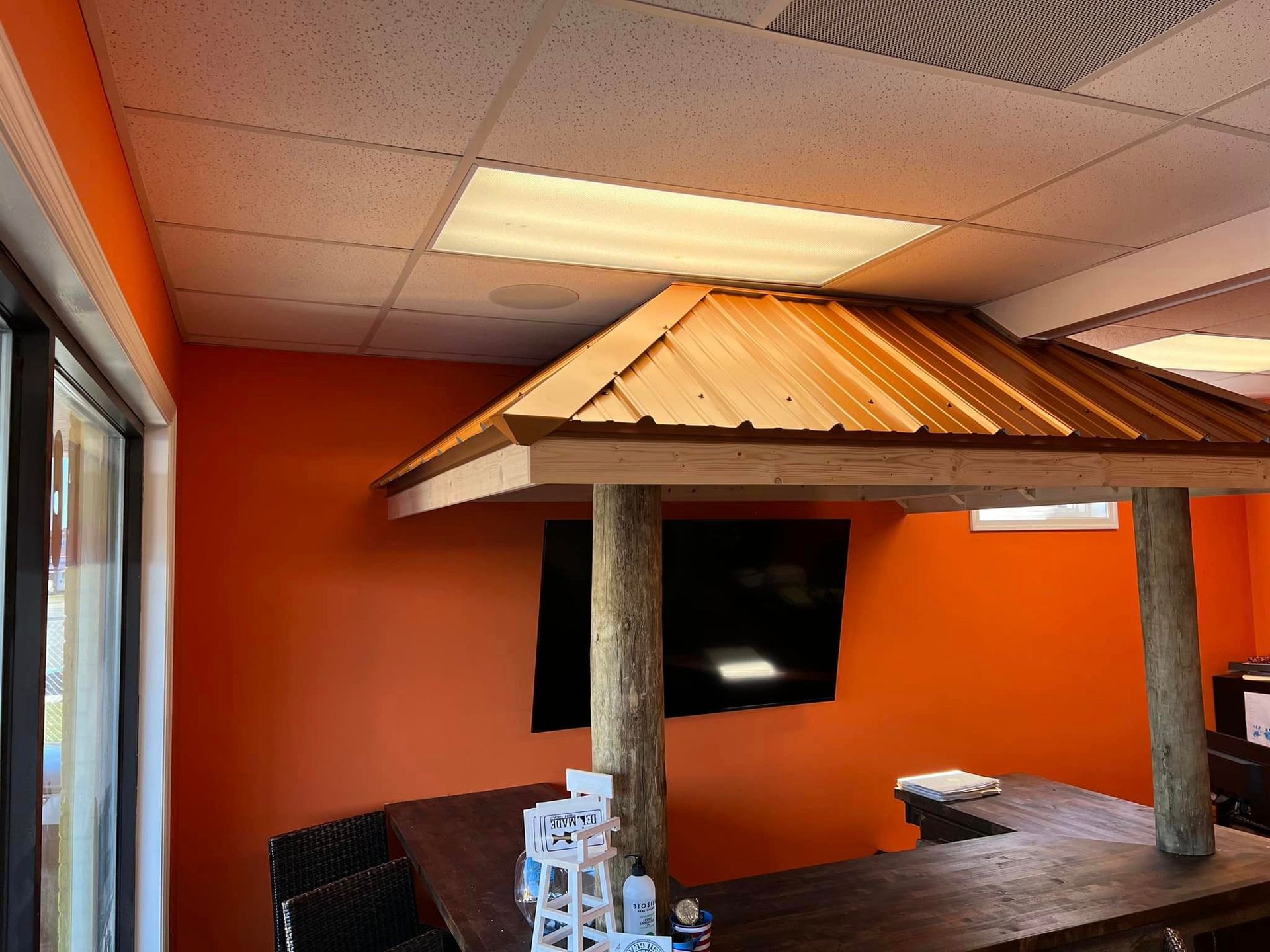 A room with orange walls and a wooden gazebo in the middle