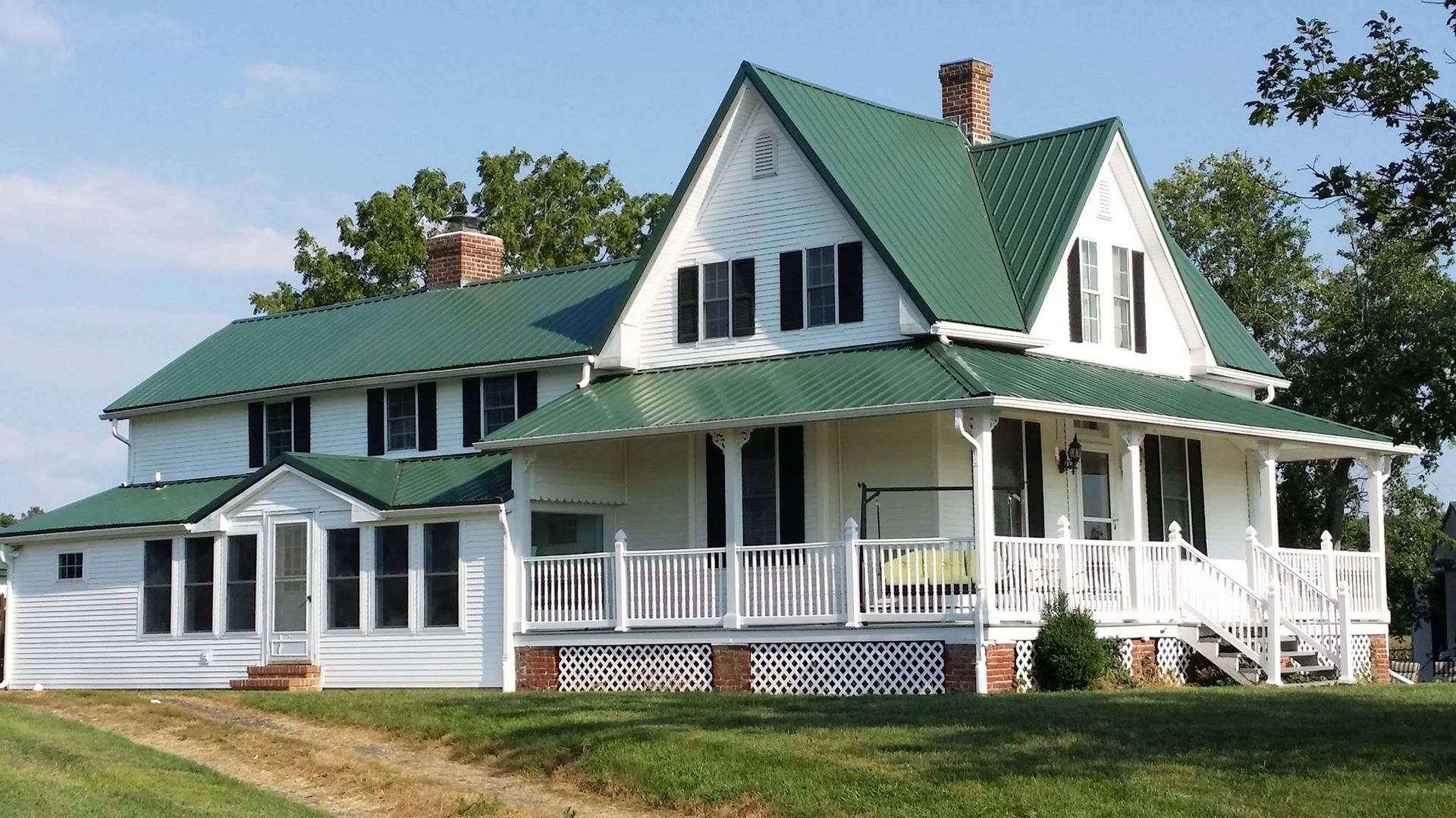 A large white house with a green roof
