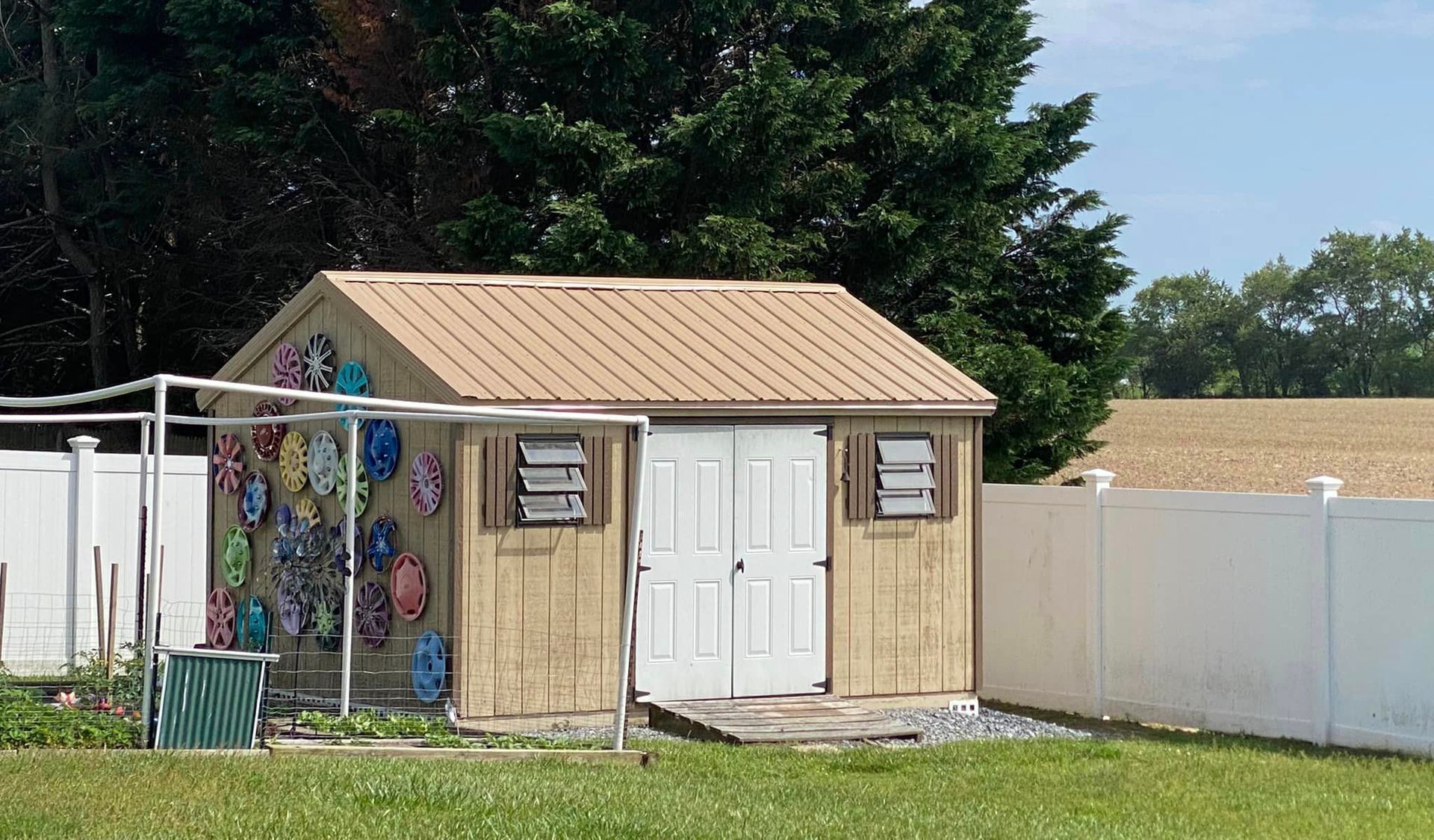 A wooden shed with a metal roof and white doors