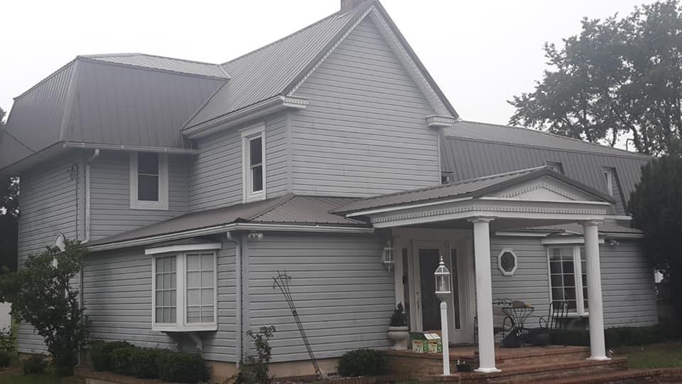 A large white house with a porch and a gray roof.