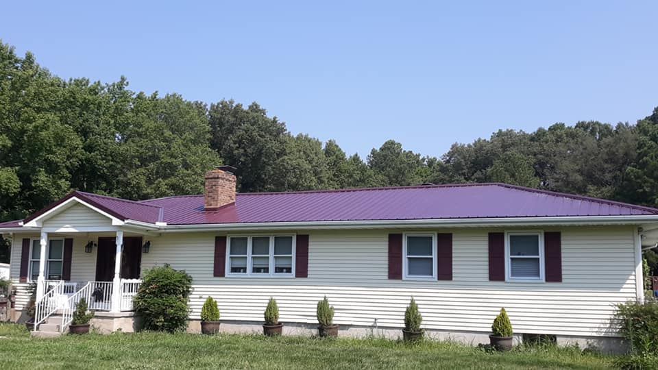 A white house with a purple roof and red shutters