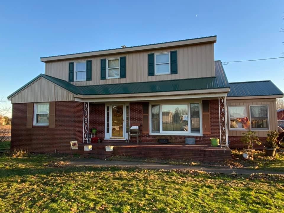 A large brick house with a green roof is for sale.