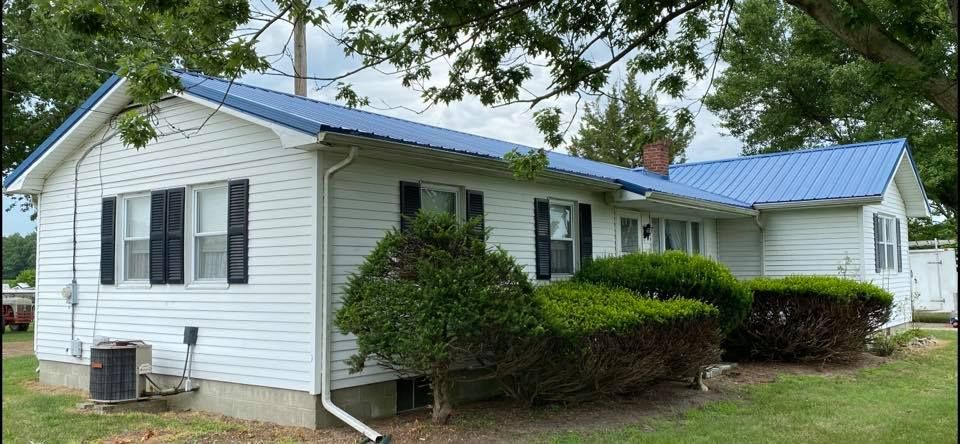 A white house with a blue roof and black shutters