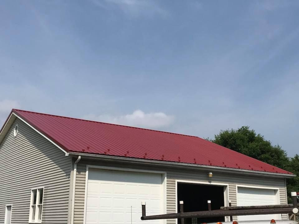 A white house with a red roof and a white garage door.