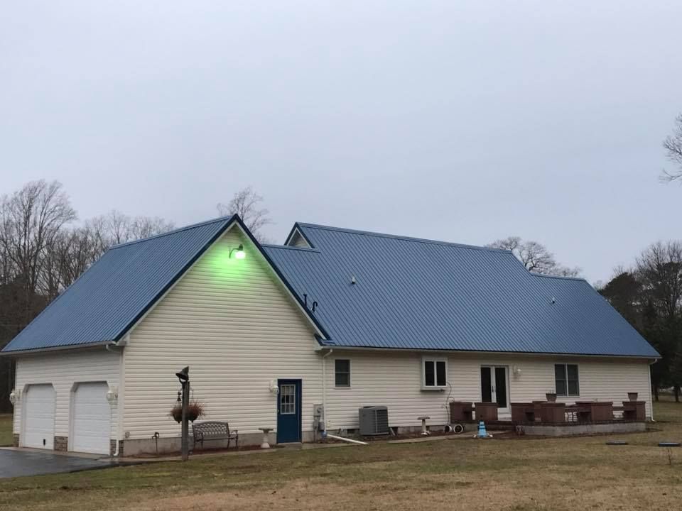 A white house with a blue metal roof