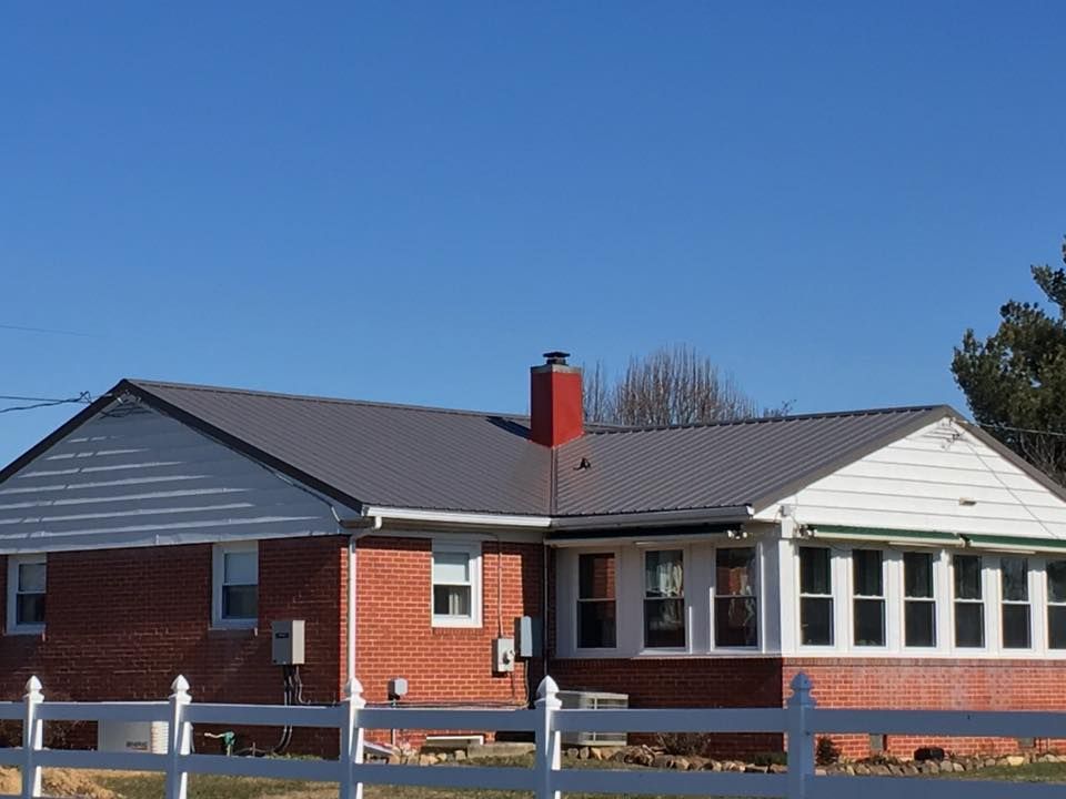 A brick house with a white fence in front of it