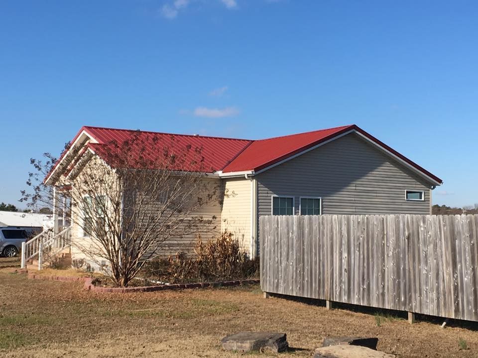 A house with a red roof and a wooden fence