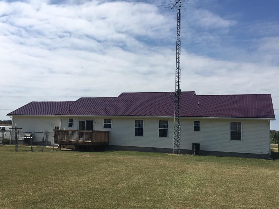 A large white house with a purple roof