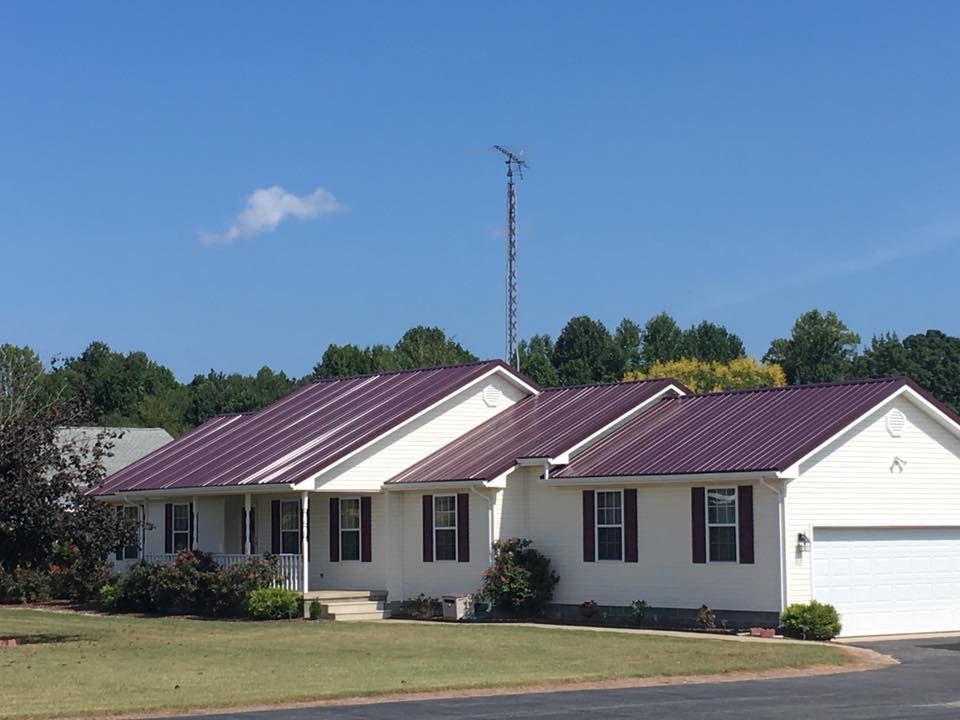 A white house with a purple roof and black shutters