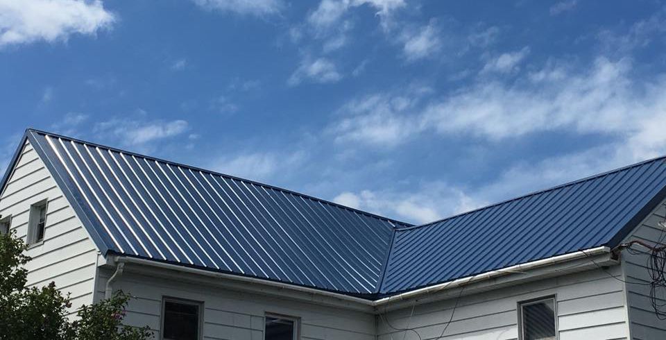 A white house with a blue roof and a blue sky in the background.