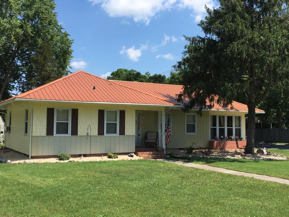 A white house with a red roof and black shutters