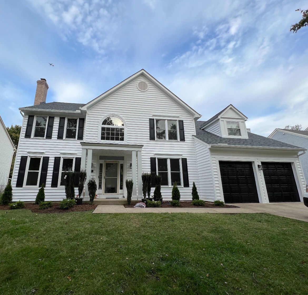 A large white house with black shutters on the windows