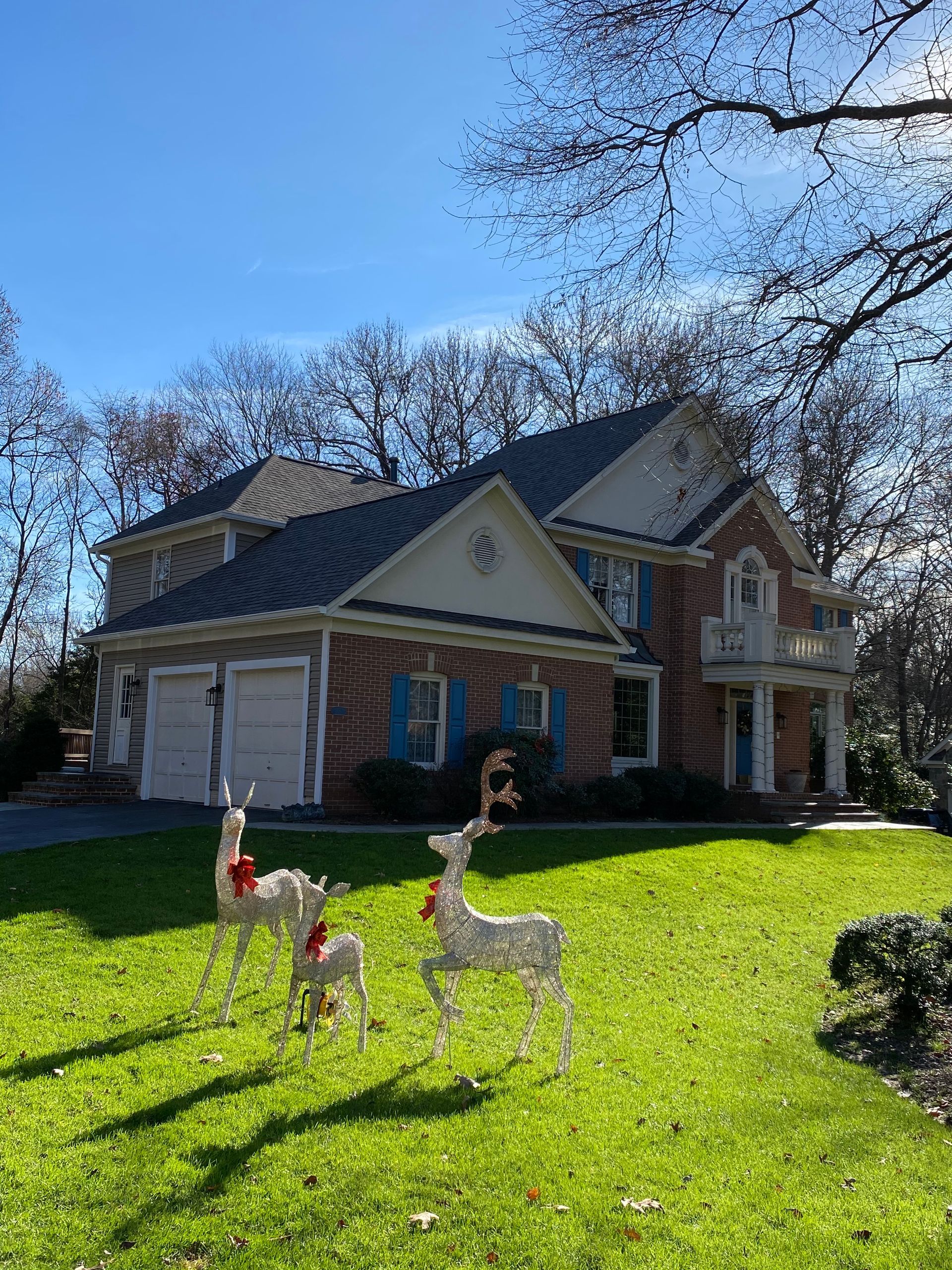 A house with three reindeer in front of it.