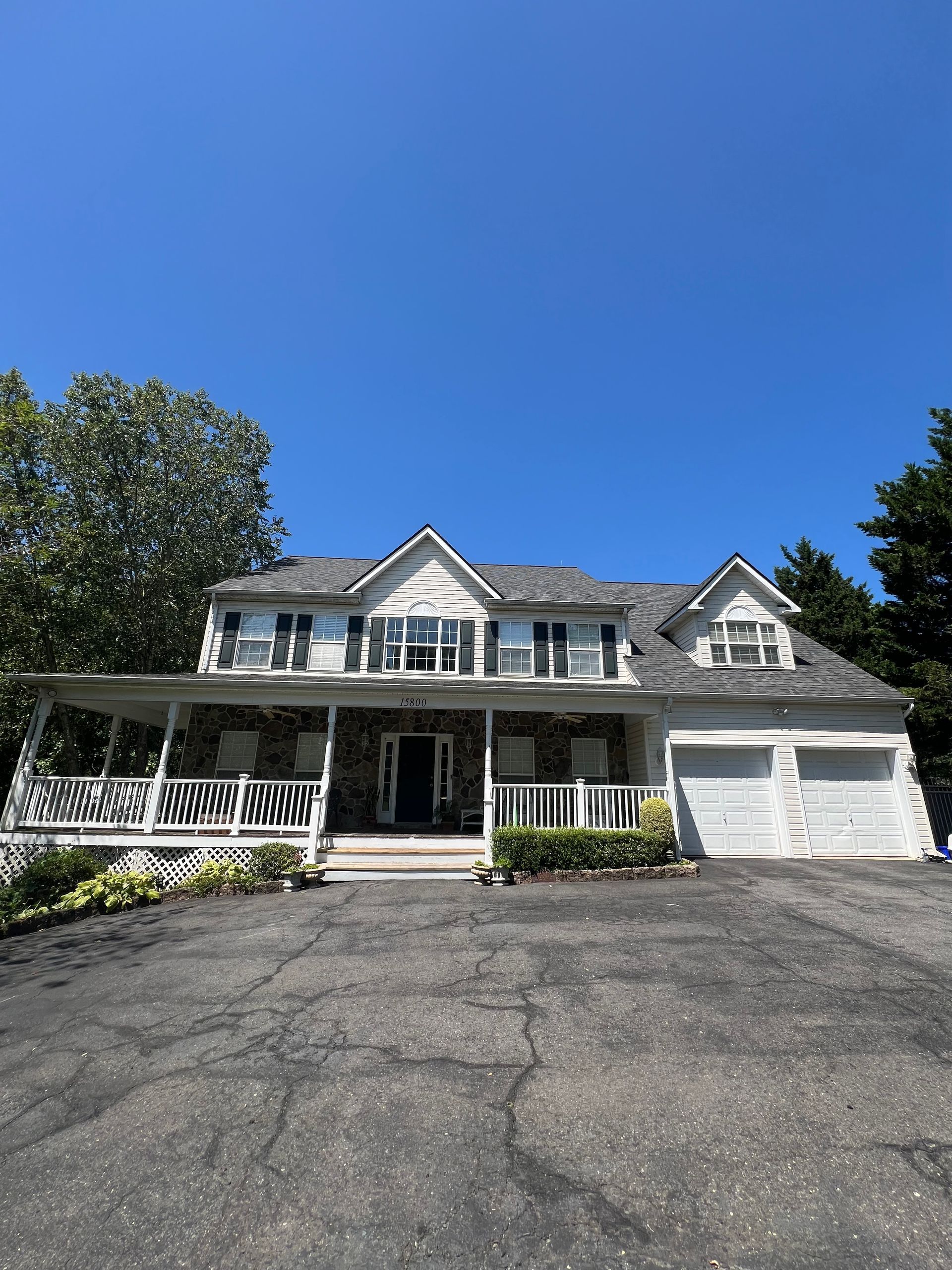 A large white house with a large porch and a garage.