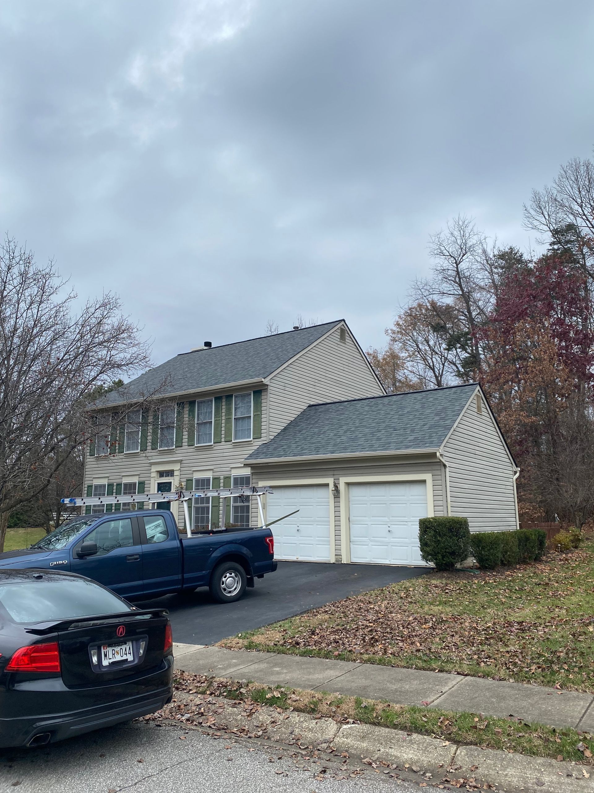 A blue truck is parked in front of a house.