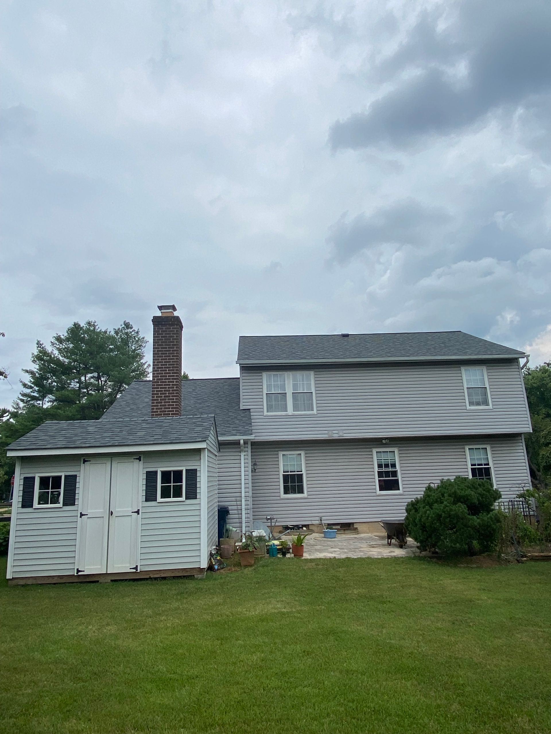 A white house with a shed in front of it