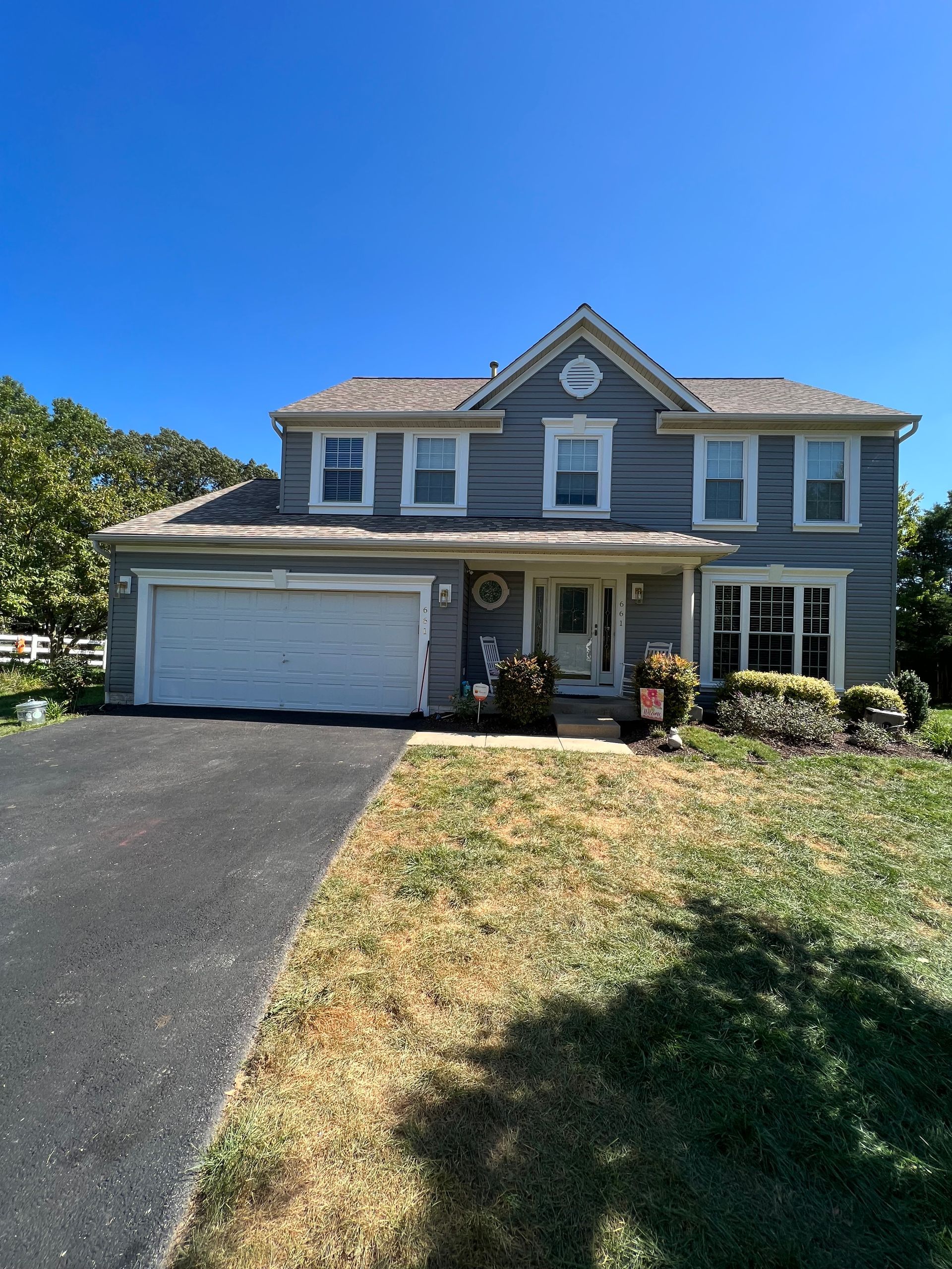 A large house with a garage and a driveway in front of it.