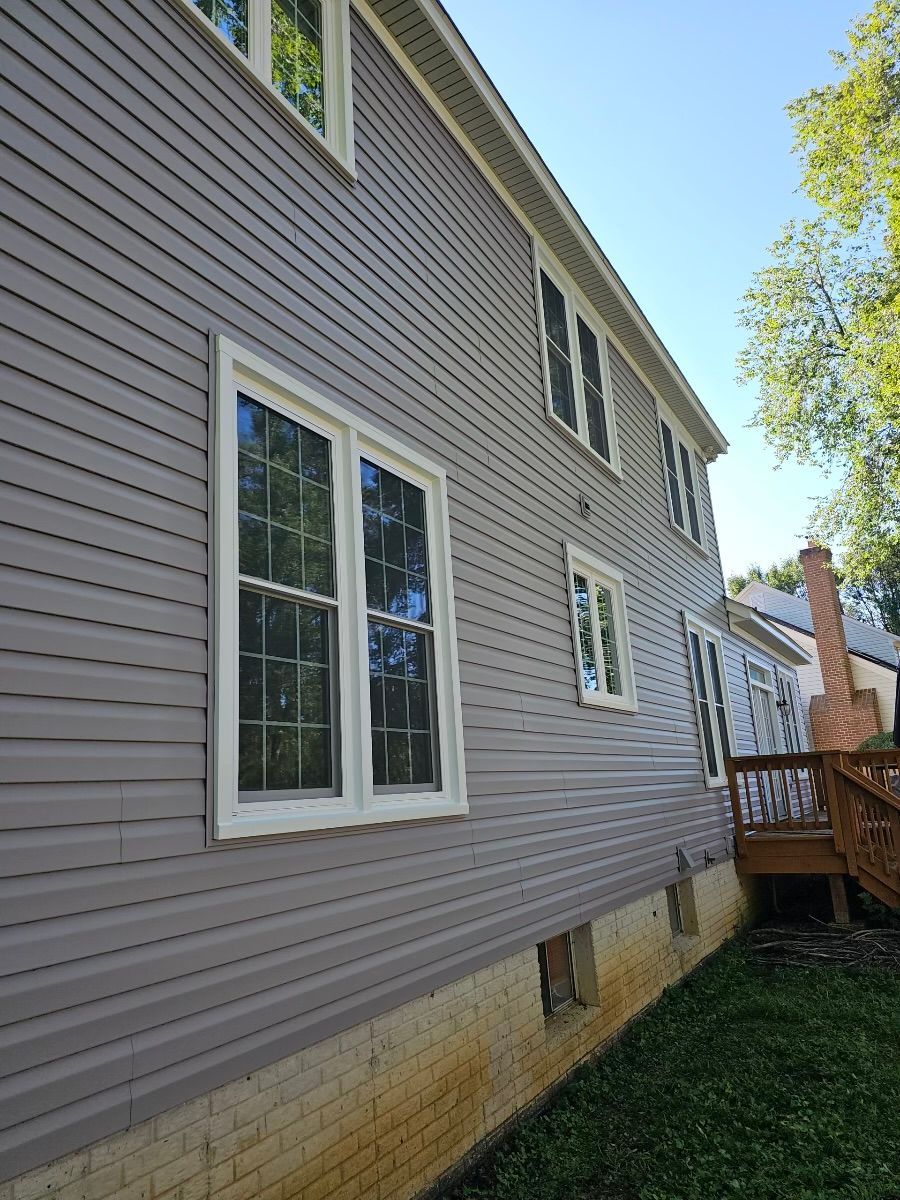 The side of a house with a lot of windows and a deck.