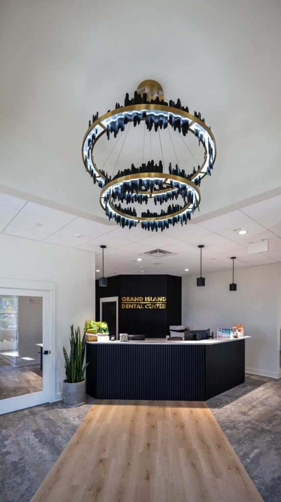 Reception desk with a large, ornate chandelier overhead.