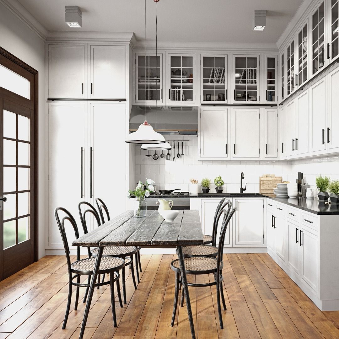 Bright white kitchen with a dining table and chairs, and a brown door on the left.