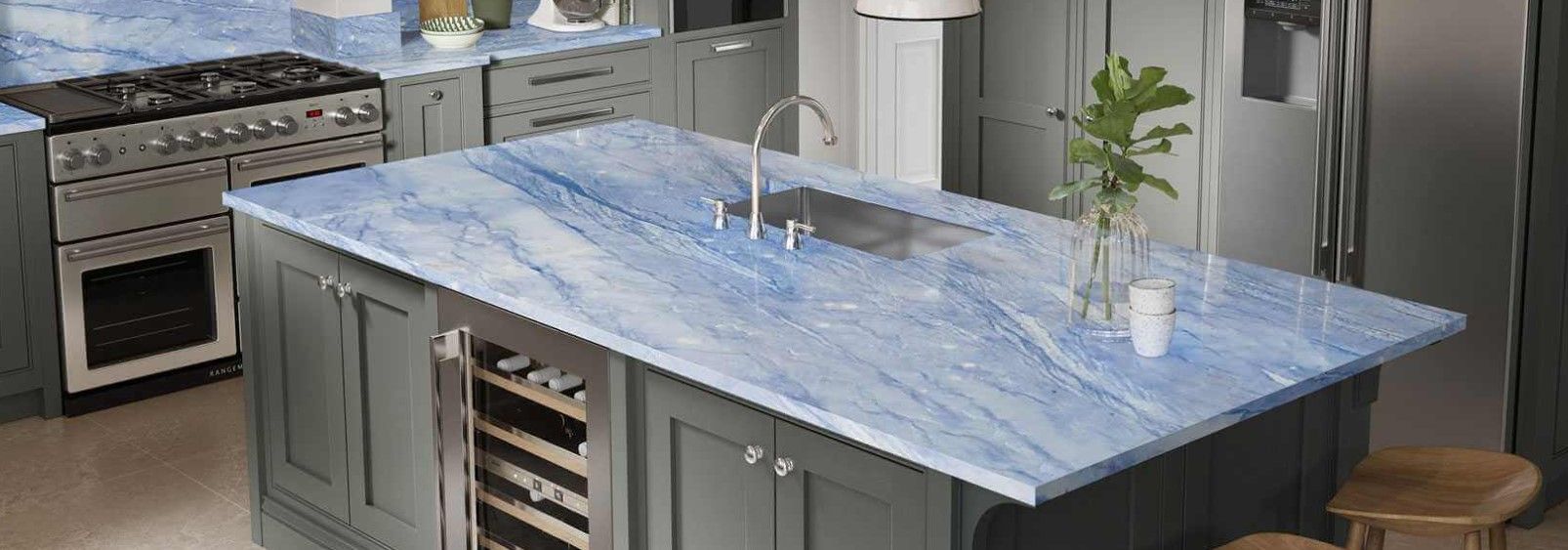 Kitchen island with blue marble countertop, sink, and cabinets with a built-in wine fridge.