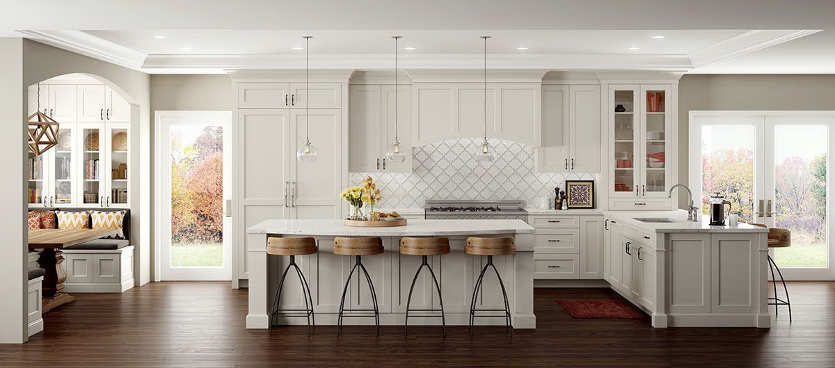 Bright, modern kitchen with white cabinetry, a large island with bar stools, and outdoor views.