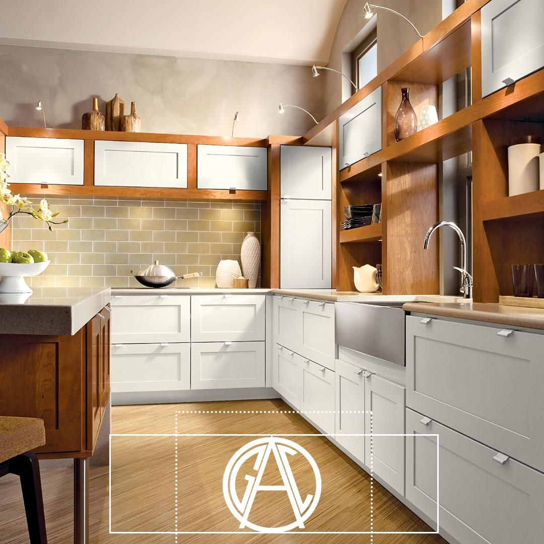 L-shaped kitchen with white cabinets, wood accents, stainless steel sink, and beige tile backsplash.