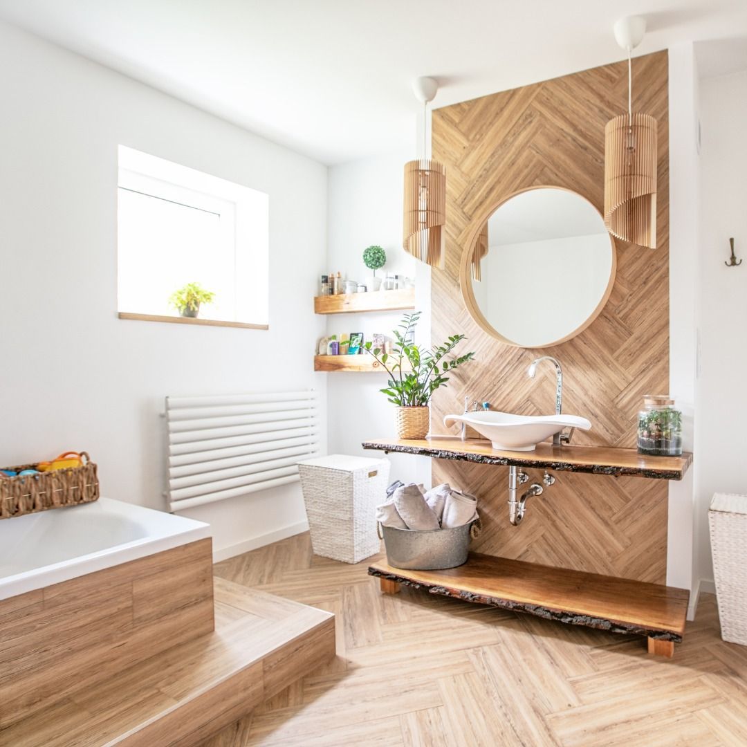 Bathroom with wood accents, including a wall, vanity, and floor. Features a tub, sink, mirror, and shelves with toiletries.
