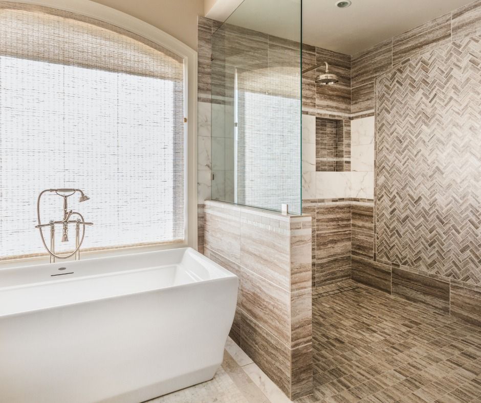 Luxurious bathroom with soaking tub, glass shower, and patterned tile.