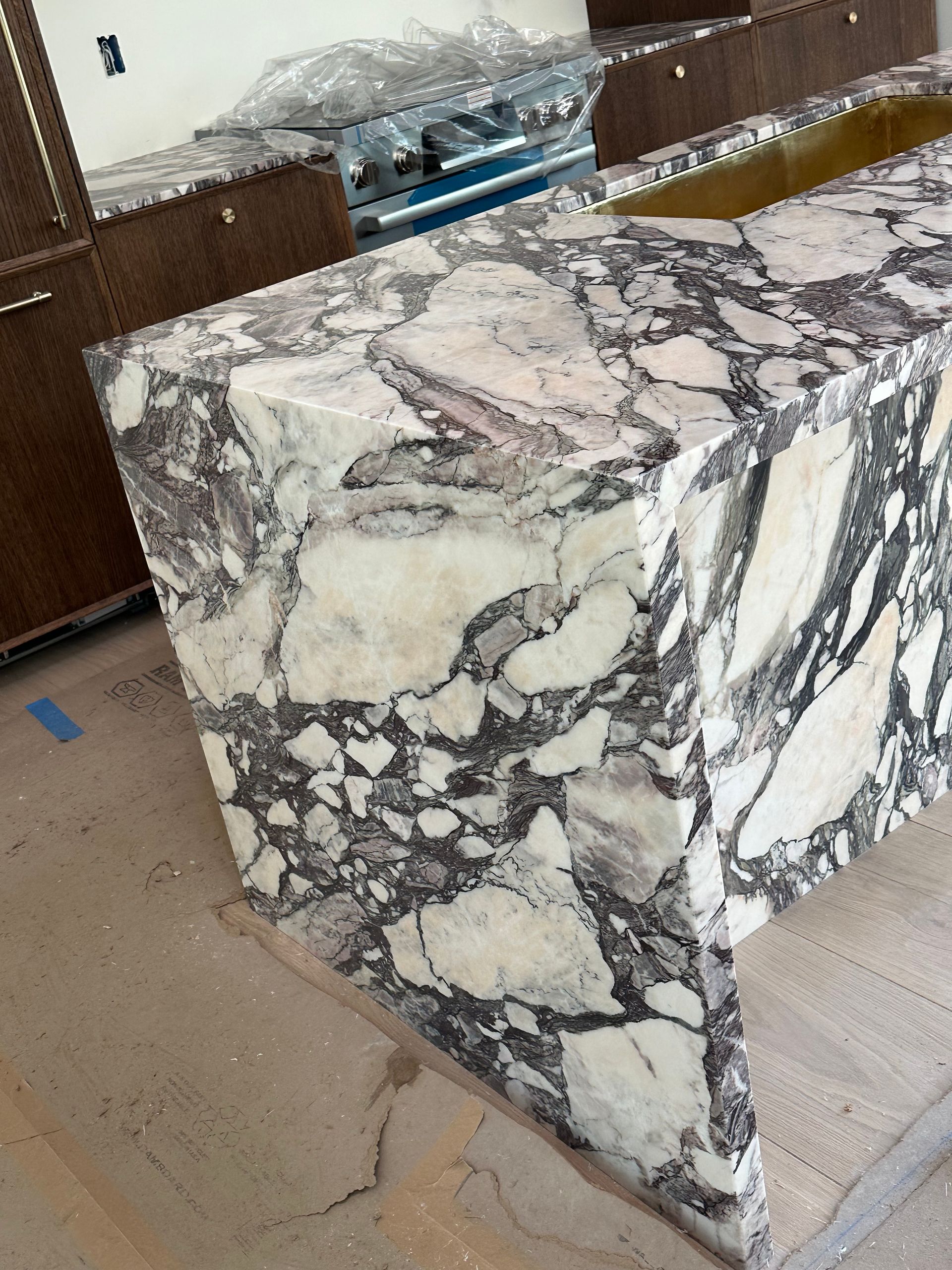 Marble countertop with black, white, and gray veining in a kitchen under construction.