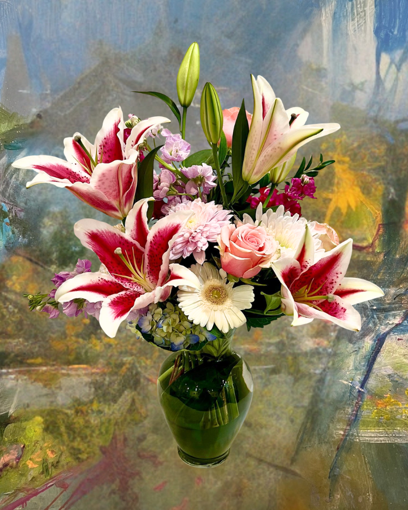 Vase of pink and white lilies and roses against an abstract painted background