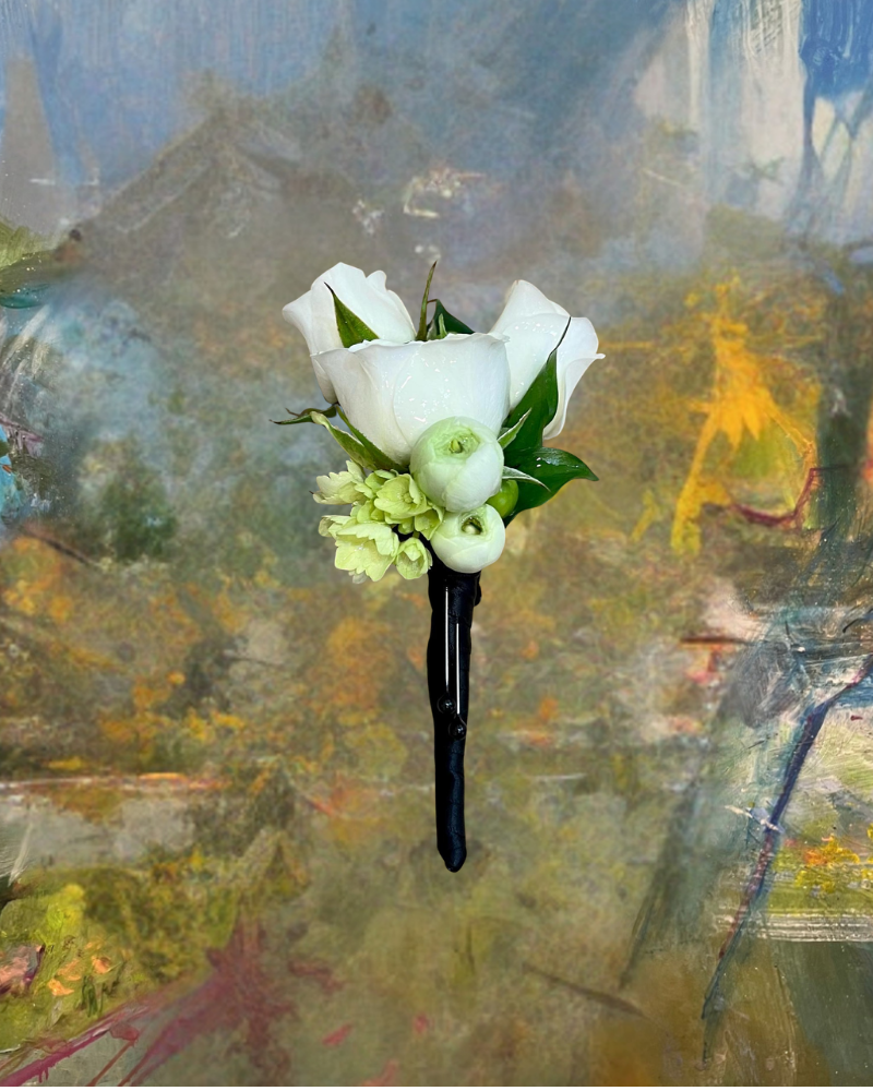 White calla lilies and green berries in a black vase against a blurred abstract background