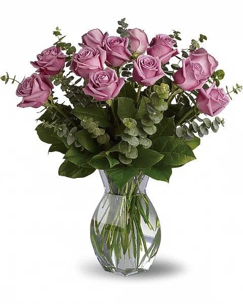Bouquet of lavender roses and eucalyptus in a clear, faceted vase.