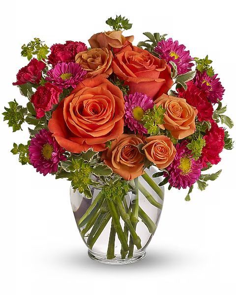 Bouquet of orange roses, pink asters, and greenery in a glass vase.