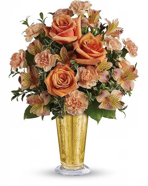 Bouquet of orange roses, carnations, and lilies in a gold vase.