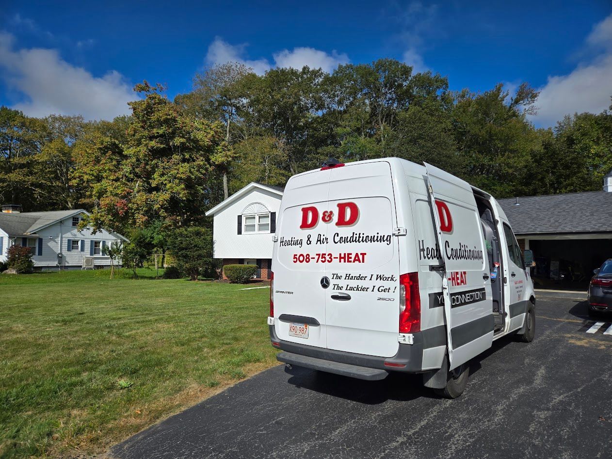 White D&D HVAC service van parked in a driveway in front of a house on a sunny day.