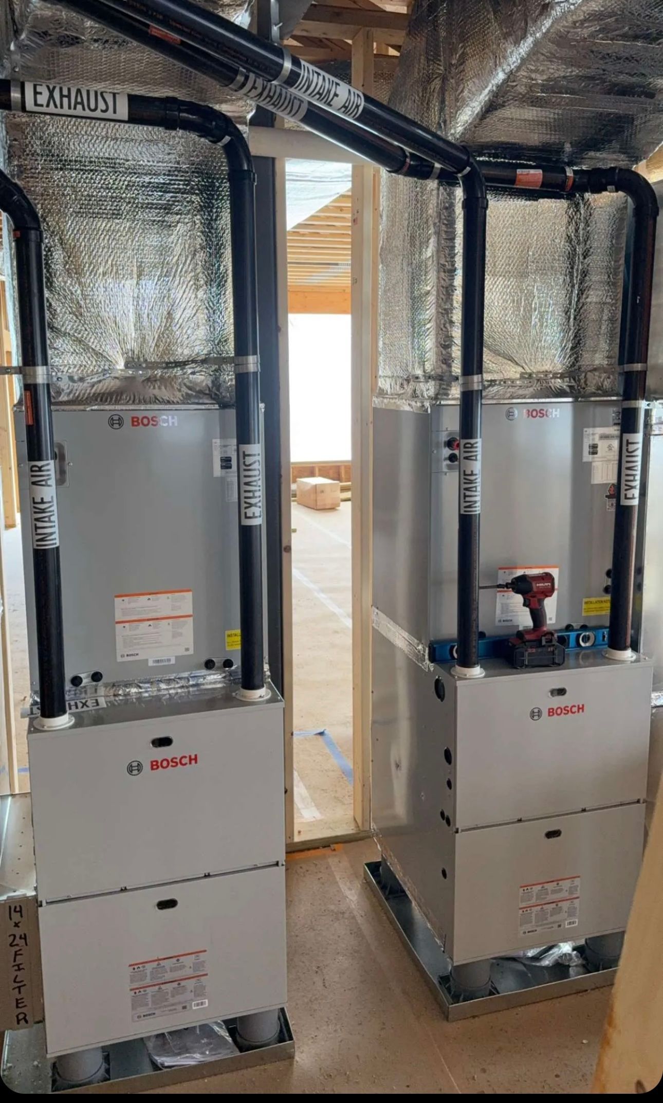 Two air conditioners are sitting next to each other in a room.