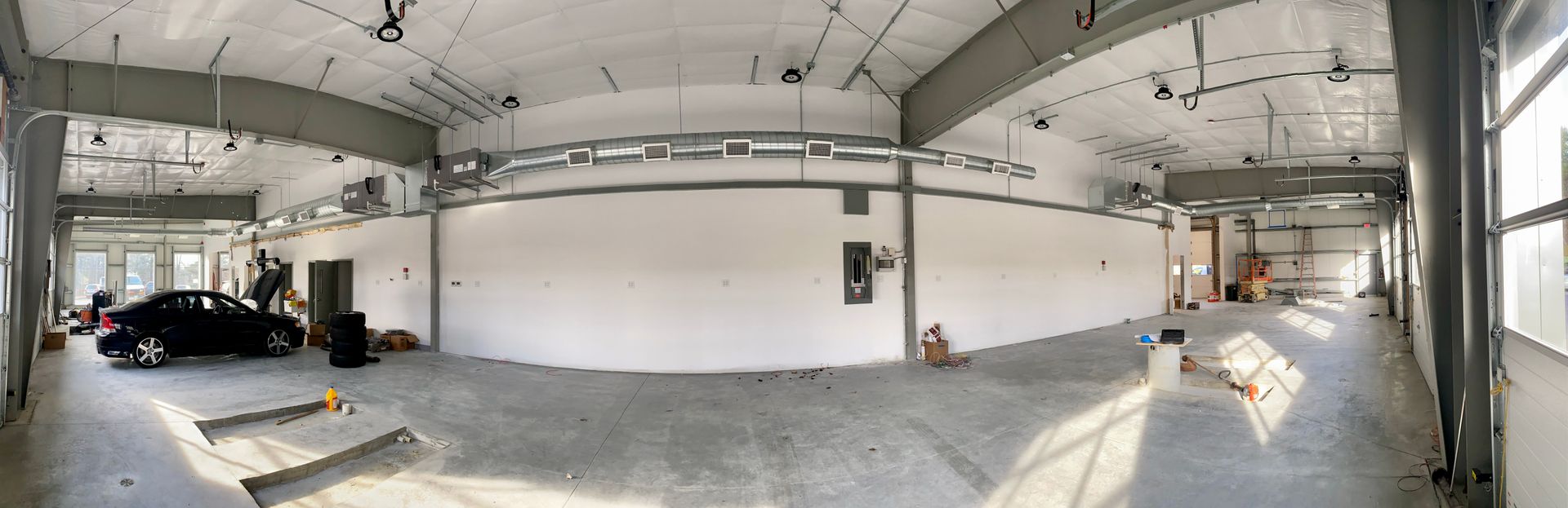 a large empty warehouse with a car parked in the middle of it