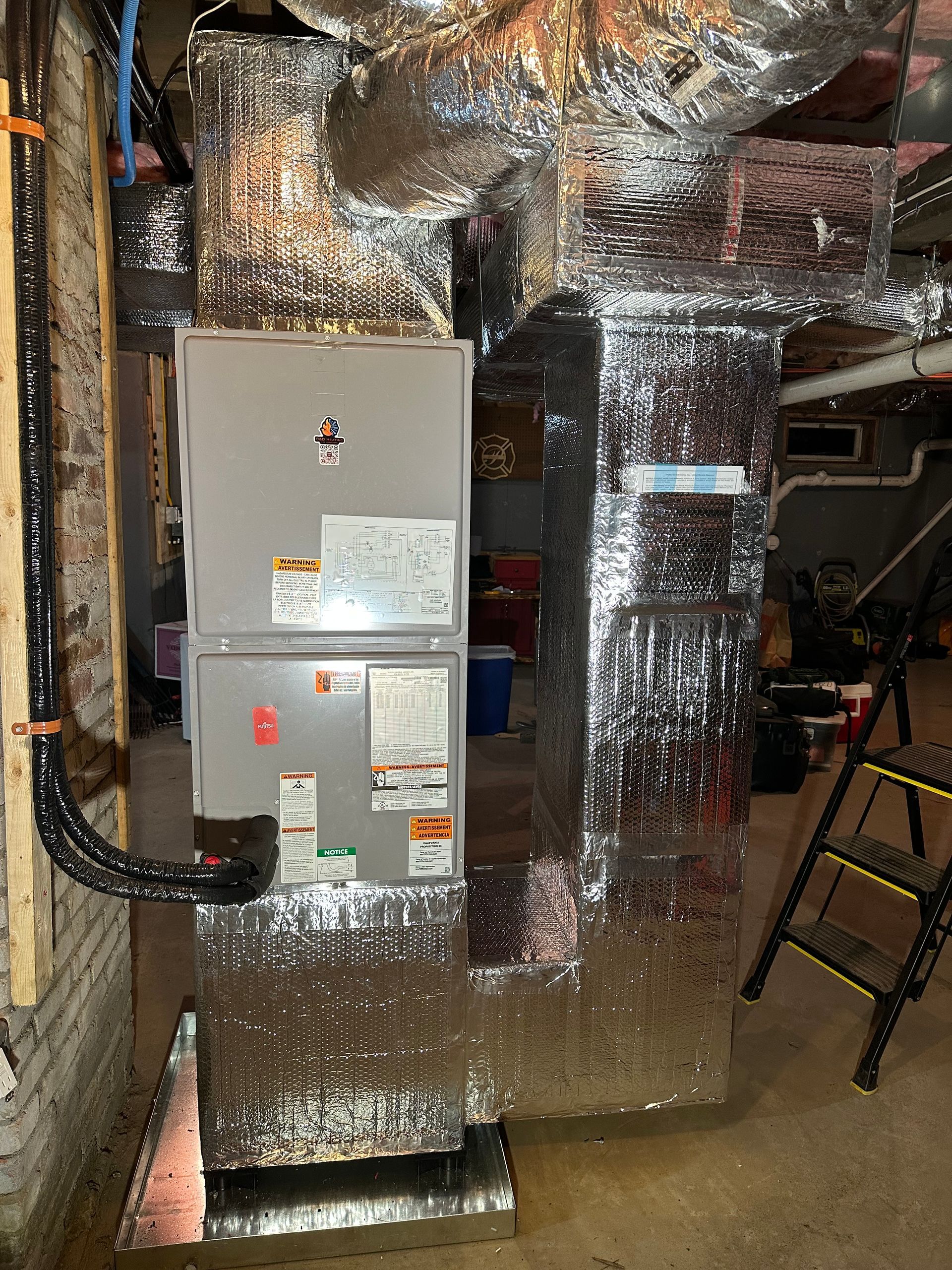 an air conditioner is sitting in a basement next to a ladder