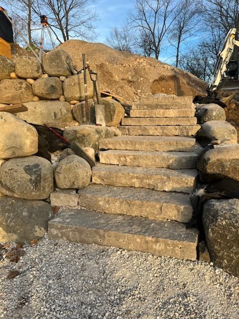 A set of stone stairs surrounded by rocks and gravel.