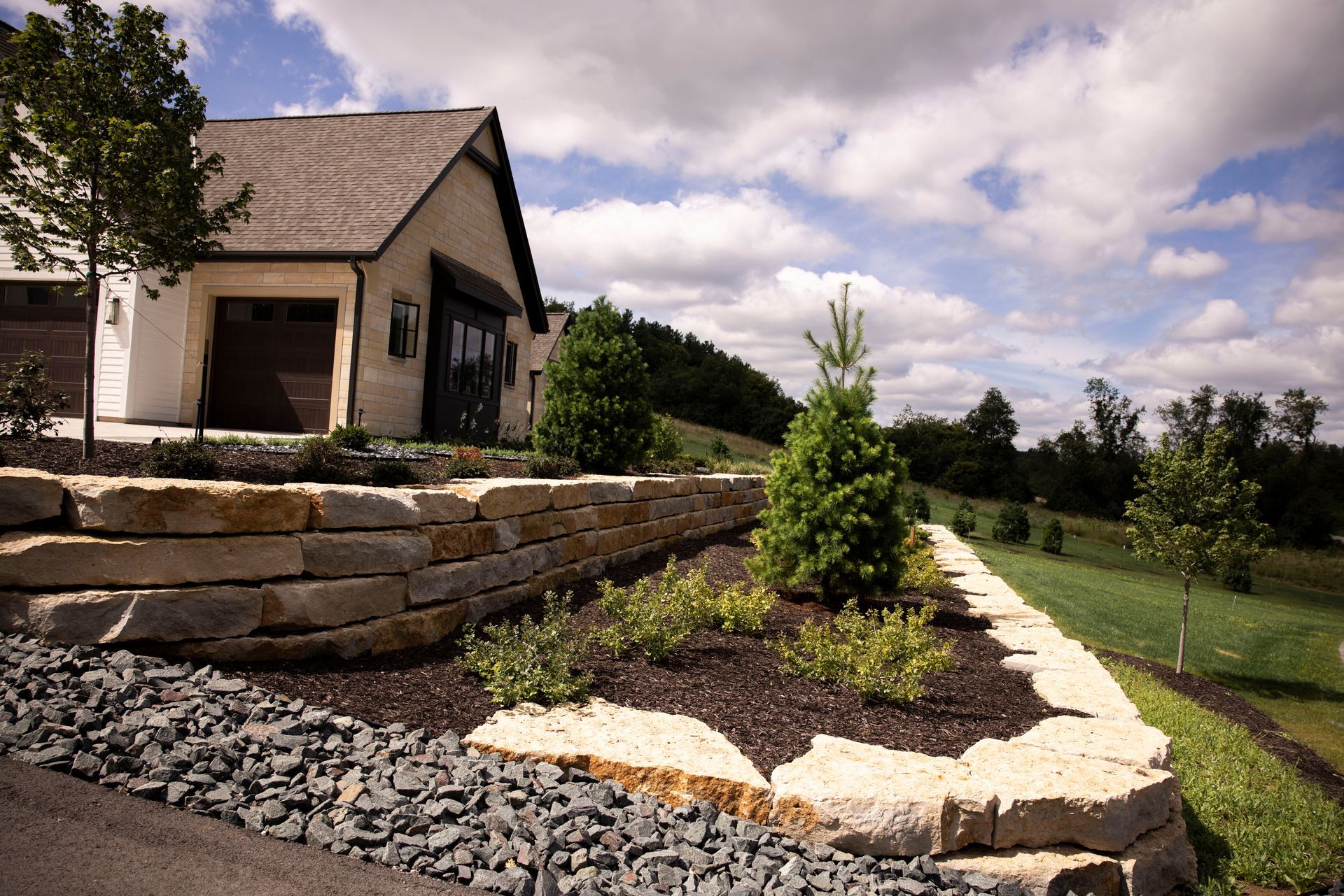 A house with a stone wall in front of it