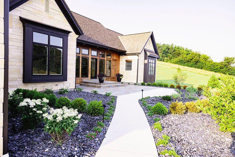 A large house with a concrete walkway leading to it.