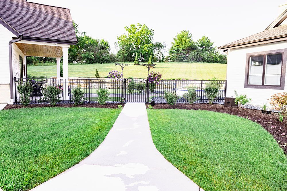 A house with a large lush green lawn in front of it.